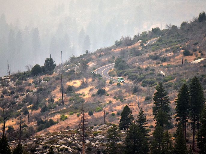 epa04334013 A photograph made available on 28 July 2014 shows US Forest Service fire engine driving down closed California Highway 120 in Yosemite National Park, California, USA, 27 July 2014. On the morning of 28 July, the fire had burned over 2,500 acres (1,011 hectares) and was just 5% contained. More than 400 firefighters and several helicopters are battling the flames near Yosemite. EPA