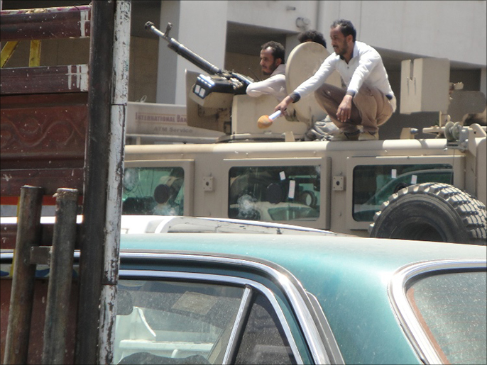 ‪مسلحون حوثيون ومدنيون فوق مدرعة عسكرية نهبت من معسكر في صنعاء‬  (الجزيرة)