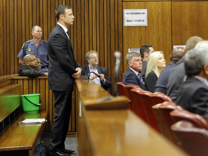 Oscar Pistorius stands in the dock in court in Pretoria, South Africa, Thursday Sept. 11, 2014 for judgement in his murder trail for the shooting death of his girlfriend Reeva Steenkamp on Valentine's Day in 2013. The judge in the Oscar Pistorius murder trial on Thursday read the reasoning behind her upcoming verdict on whether the double-amputee athlete intentionally killed girlfriend Reeva Steenkamp. (AP Photo/Kim Ludbrook, Pool)