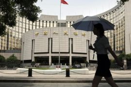 A woman walks past the headquarters of the People's Bank of China (PBOC), the central bank, in Beijing, in this file picture taken June 21, 2013. China's central bank is injecting a combined 500 billion yuan ($81.35 billion) of liquidity into the country's top banks, according to media reports, a sign that authorities are stepping up efforts to shore up a faltering economy REUTERS/Jason Lee/Files (CHINA - Tags: BUSINESS POLITICS)