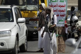 Shi'ite Houthi rebels man a checkpoint in Sanaa September 24, 2014. The leader of a Shi'ite rebel group on Tuesday hailed the takeover by his fighters of much of the Yemeni capital after four days of fighting last week as a "successful revolution" for all citizens. The banner reads "Allah is the greatest. Death to America, death to Israel, a curse on the Jews, victory to Islam". REUTERS/Khaled Abdullah (YEMEN - Tags: POLITICS CIVIL UNREST)