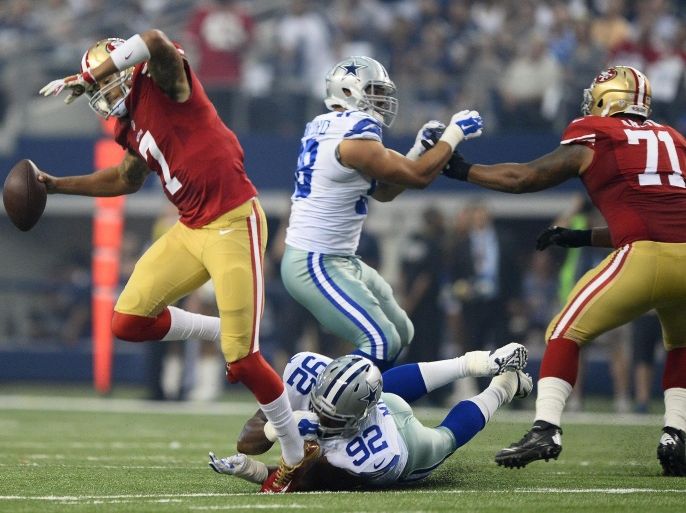 San Francisco 49ers quarterback Colin Kaepernick (L) scrambles before throwing a pass for a touchdown against Dallas Cowboys player Jeremy Mincey (C) in the first half of the NFL American football game between the San Francisco 49ers and the Dallas Cowboys at the AT&T Stadium in Arlington, Texas, USA, 07 September 2014.