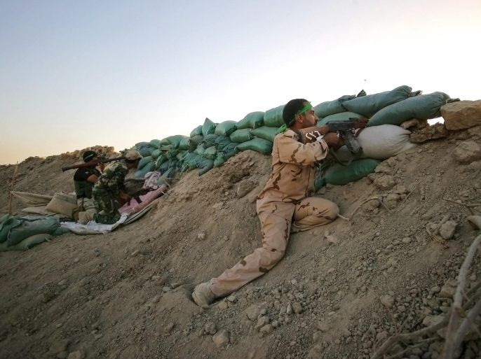 In this Sunday, Sept. 28, 2014 photo, an Iraqi Shiite militiamen aim their weapons during clashes with militants from the Islamic State group, in Jurf al-Sakhar, 43 miles (70 kilometers) south of Baghdad, Iraq. (AP Photo)