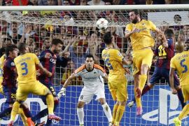 Barcelona's Gerard Pique (3rd L) goes for the ball before scoring his goal against Apoel FC goalkeeper Urko Pardo (C) during their Champions League soccer match at Nou Cap stadium in Barcelona September 17, 2014. REUTERS/Gustau Nacarino (SPAIN - Tags: SPORT SOCCER)
