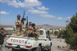 صورة لمقاتلين من درعا في القنيطرة ويظهر وراءهم تل الحارة
