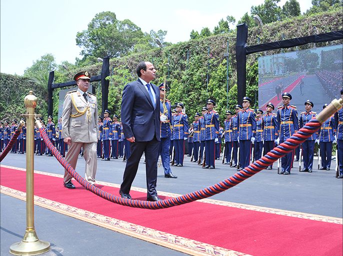 epa04245323 A handout photograph made available by the Egyptian Presidency shows President elect Abdel Fattah al-Sissi (C) reviewing the Guard of Hounour at the Presidential Palace in Cairo, Egypt, 08 June 2014. Former army chief Abdel