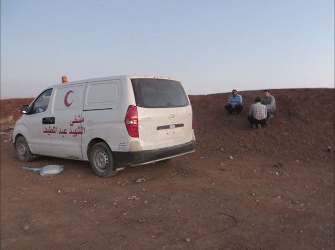 الصورة لمسعفين ينتظرون قبول الجانب الاردني لدخول احد الجرحى بعدما ادخلوه الى النقطة الطبية على الحدود الاردنية السورية