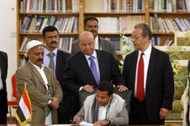 Head of the political relations department of the Houthi movement, Hussein al-Ezzi (seated), signs an agreement, next to U.N. special envoy Jamal Benomar (2nd R), in Sanaa September 21, 2014. Houthi rebels on Sunday signed the deal, brokered by U.N. special envoy Jamal Benomar, intended to end the fighting and pave the way for a new government within two weeks. Yemen's prime minister submitted his resignation on Sunday amid chaos over reported advances by Shi'ite Muslim Houthi rebels on some military buildings and government offices in the capital. REUTERS/Mohamed al-Sayaghi (YEMEN - Tags: POLITICS CIVIL UNREST)