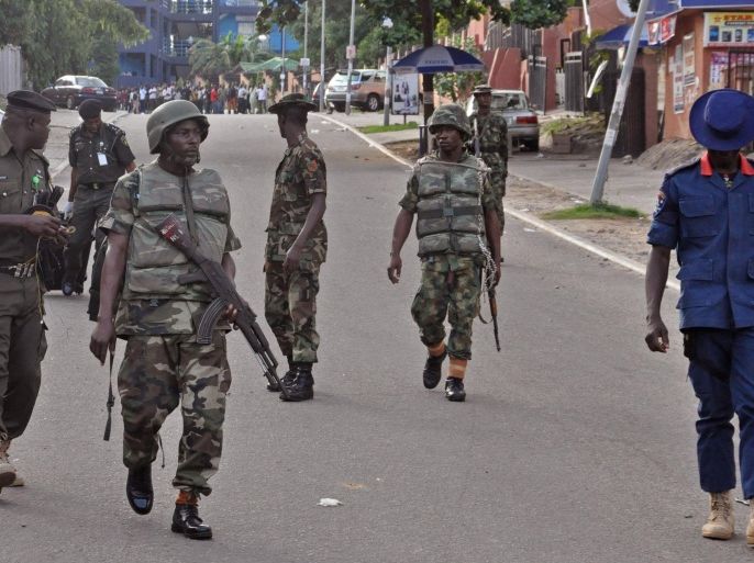 Nigerian soldiers patrol the area, near the scene of an explosion in Abuja, Nigeria, Wednesday, June 25, 2014. An explosion rocked a shopping mall in Nigeria's capital, Abuja, on Wednesday and police say at least over 20 people have been killed and many wounded. Witnesses say body parts were scattered around the exit to Emab Plaza, in the upscale Wuse 11 suburb. (AP Photo/Olamikan Gbemiga)