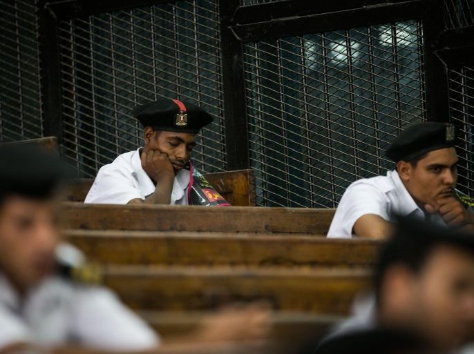 Egyptian court security members take a break during a sentencing for the Egyptian Muslim Brotherhood leader, Mohamed Badie, at a court in Cairo, on August 30, 2014. An Egyptian court commuted to life imprisonment the death sentence that had been pronounced against the Egyptian Muslim Brotherhood leader, Mohamed Badie, according to state television and defence lawyers. Four other members of the Brotherhood were sentenced to life imprisonment while six others, tried in absentia , were sentenced to the death penalty. AFP PHOTO/ MOHAMED EL-SHAHED