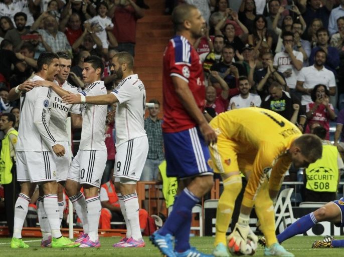 Real's Cristiano Ronaldo, left, celebrates his goal with teammates during a Champions League final Group B soccer match between Real Madrid and FC Basel at the Santiago Bernabeu stadium in Madrid, Spain, Tuesday, Sept. 16, 2014. (AP Photo/Gabriel Pecot)
