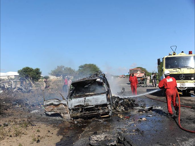 إطفائي يخمد إحدى الحافلات الصغيرة تضررت في تفجير السيارة المفخخة في منطقة عالامادا جنوب مقديشو 8 سبتمبر 2014 (الجزيرة نت).