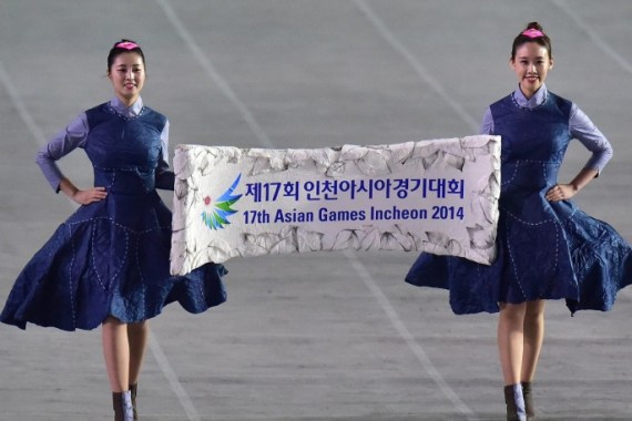 Hostesses carry a placard during the opening ceremony of the 2014 Asian Games at the Incheon Asiad Main Stadium in Incheon on September 19, 2014. AFP PHOTO / JUNG YEON-JE