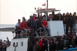 epa02645080 A boat carrying immigrants arrives to the Italian island of Lampedusa, Italy, 20 March 2011. Pressures continued to mount on Lampedusa on 19 March as refugee centres began to buckle under the weight of the inflow of people and residents? continued to protest the refugees? presence. EPA