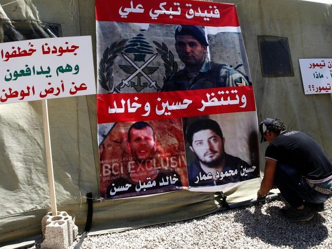 A relatives of one of the Lebanese soldiers kidnapped by fighters linked to the radical Sunni Islamic State (IS) and al-Nusra Front (JAN), attaches a poster with pictures of those kidnapped to a tent in Martyrs' Square in Beirut, Lebanon, 10 September 2014. According to media reports, 29 soldiers were abducted following clashes between Lebanese security forces and militants suspected of being part of JAN and IS that erupted on 02 August near the town of Arsal close to the Syrian border, a statement was released by militants 30 August saying nine soldiers would be killed if Islamist prisoners held by Lebanon were not released following which five Lebanese soldiers were released 31 August though 24 are still being held and one was beheaded 06 September for allegedly trying to escape.