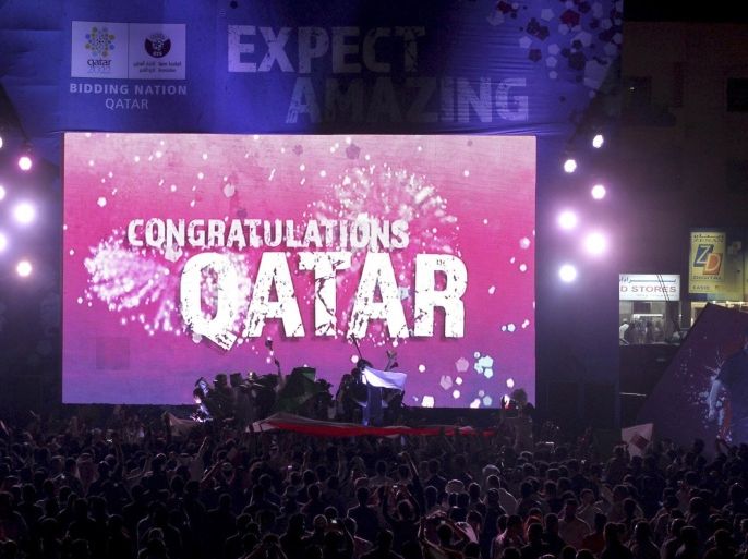 People celebrate in front of a screen that reads "Congratulations Qatar" after FIFA announced that Qatar will be host of the 2022 World Cup in Souq Waqif in Doha, in this December 2, 2010 file picture. The 2022 World Cup will not be held in Qatar because of the scorching temperatures in the Middle East country, FIFA Executive Committee member Theo Zwanziger said on September 22, 2014. REUTERS/Fadi Al-Assaad/Files (QATAR - Tags: SPORT SOCCER)