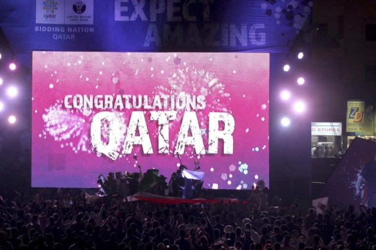 People celebrate in front of a screen that reads "Congratulations Qatar" after FIFA announced that Qatar will be host of the 2022 World Cup in Souq Waqif in Doha, in this December 2, 2010 file picture. The 2022 World Cup will not be held in Qatar because of the scorching temperatures in the Middle East country, FIFA Executive Committee member Theo Zwanziger said on September 22, 2014. REUTERS/Fadi Al-Assaad/Files (QATAR - Tags: SPORT SOCCER)