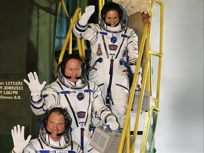 Members of expedition to the International Space Station Russian cosmonaut Alexander Samokutyaev, bottom, Russian cosmonaut Elena Serova, top, and NASA astronaut Barry Wilmore, center, wave during a farewell ceremony as they enter the spacecraft Soyuz TMA-14M before the launch at the Baikonur Cosmodrome, Kazakhstan, Thursday, Sept. 25, 2014. (AP Photo/Yuri Kochetkov, Pool)