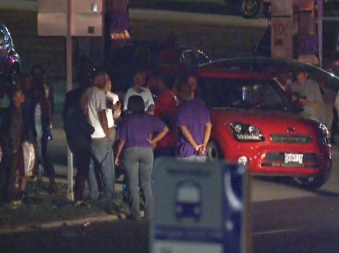 In this framegrab image courtesy of KSDK-TV a crowd gathers near the scene where a police officer was shot in the arm Saturday night Sept. 27, 2014 in Ferguson, Missouri. The officer was shot in the arm and is expected to survive, St. Louis County Police Chief Jon Belmar said. (AP Photo/KSDK-TV)