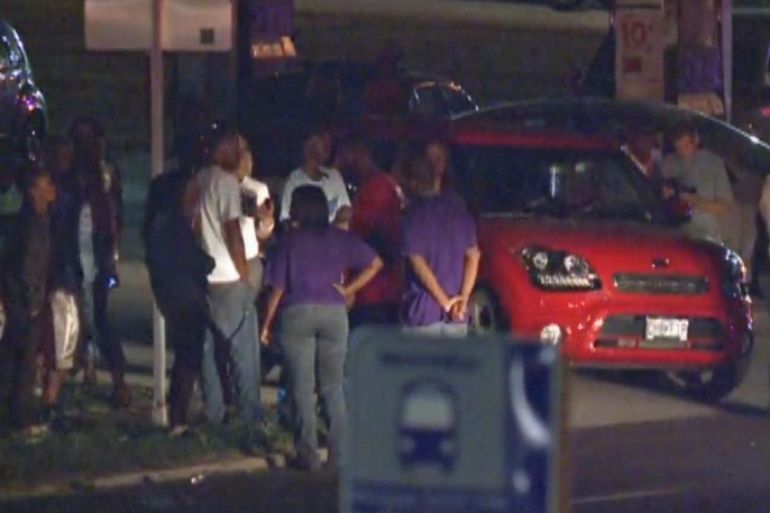 In this framegrab image courtesy of KSDK-TV a crowd gathers near the scene where a police officer was shot in the arm Saturday night Sept. 27, 2014 in Ferguson, Missouri. The officer was shot in the arm and is expected to survive, St. Louis County Police Chief Jon Belmar said. (AP Photo/KSDK-TV)