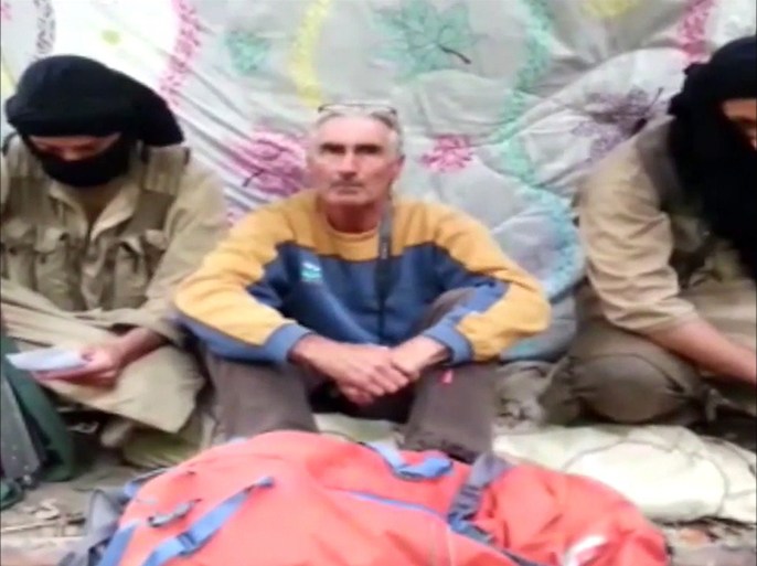 An image grab taken from a video released by Jund al-Khilifa group viao YouTube on September 22, 2014, allegedly shows French tourist, Herve Pierre Gourdel (C), sitting between two armed jihadists at an undisclosed location. An Algerian militant group said it has kidnapped a Frenchman and threatened to execute him unless Paris halts air strikes on Islamic State jihadists in Iraq, in a video posted on YouTube. AFP