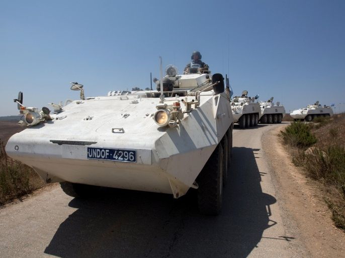 Irish members of United Nations Disengagement Observer Force (UNDOF) convoy maneuver, near the border of Syrian territory, close to the town of Buqaata in the Israeli-annexed Golan Heights on August 31, 2014. Heavy fighting between Syrian government troops and opposition forces flowed into the buffer zone separating Syrian and Israeli-occupied territory at the weekend. Dozens of Filipino UN peacekeepers escaped the hot zone overnight after rebels rammed their Golan Heights outpost with armed trucks, the Philippine military said. AFP PHOTO/ MENAHEM KAHANA