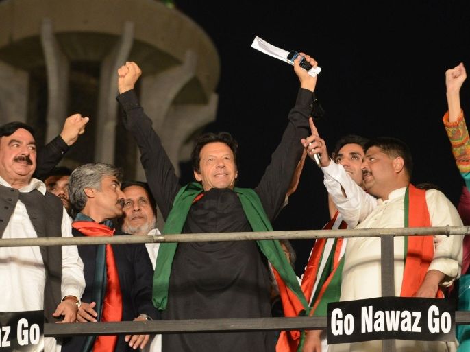 Pakistani opposition leader Imran Khan (C) gestures upon his arrival at an anti-government protest in Lahore on September 28, 2014. Khan and cleric Tahir-ul-Qadri have set up camp cities in front of parliament in Islamabad hoping to force the resignation of Prime Minister Nawaz Sharif, whom they accuse of rigging last year's general election. AFP PHOTO/Arif ALI