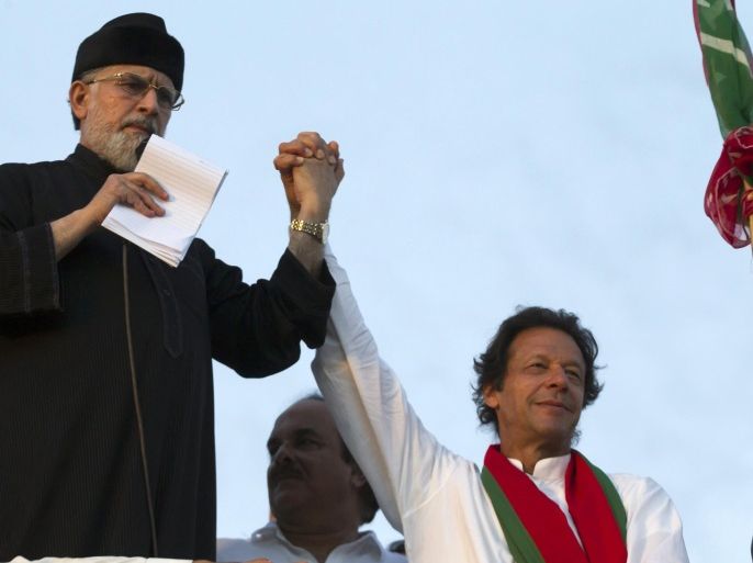 Tahir ul-Qadri (L), Sufi cleric and leader of political party Pakistan Awami Tehreek (PAT) holds the hand of Imran Khan, the Chairman of the Pakistan Tehreek-e-Insaf (PTI) political party while addressing supporters during the Revolution March in Islamabad September 2, 2014. Pakistan is preparing to launch a selective crackdown against anti-government protesters trying to bring down the government of Prime Minister Nawaz Sharif, the defense minister said, warning demonstrators against storming government buildings. REUTERS/Zohra Bensemra (PAKISTAN - Tags: POLITICS CIVIL UNREST)