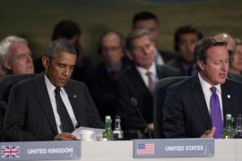 U.S. President Barack Obama reads a piece of paper as British Prime Minister David Cameron, right, speaks at the start of a NATO-Afghanistan round table meeting during a NATO summit at the Celtic Manor Resort in Newport, Wales on Thursday, Sept. 4, 2014. In a two-day summit leaders will discuss, among other issues, the situation in Ukraine and Afghanistan. (AP Photo/Matt Dunham)