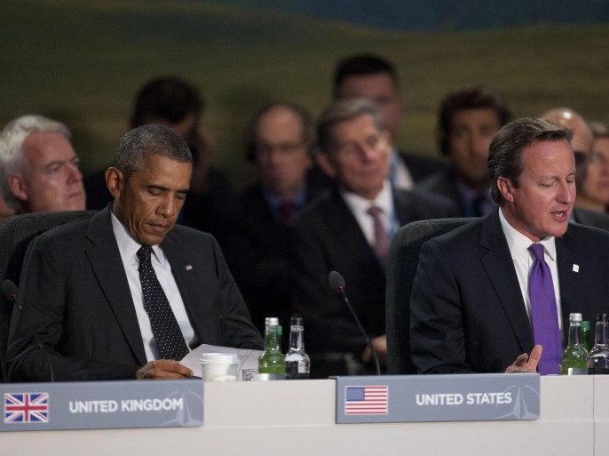 U.S. President Barack Obama reads a piece of paper as British Prime Minister David Cameron, right, speaks at the start of a NATO-Afghanistan round table meeting during a NATO summit at the Celtic Manor Resort in Newport, Wales on Thursday, Sept. 4, 2014. In a two-day summit leaders will discuss, among other issues, the situation in Ukraine and Afghanistan. (AP Photo/Matt Dunham)