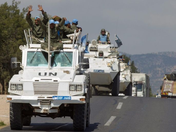 UN troops wave from their vehicles as they leave Syria and cross into Israel, from the northern part of the Israeli-Syrian border, near the Syrian village of Jubata Al Khashab, in the Golan Heights, 15 September 2014. A UN Military Police Officer confirmed that troops of the UN Disengagement Observer Force (UNDOF) were withdrawing from the Syrian part of the Golan Heights due to security reasons. The UNDOF is monitoring a 1974 ceasefire agreement between Israel and Syria on the Golan Heights.
