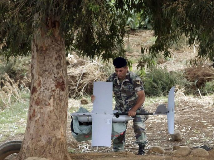 A Lebanese Army soldier carries an Israeli drone in the Marjeyoun countryside, south Lebanon September 20, 2014. The Lebanese Army found the MK drone that fell in the Marjeyoun countryside near the Lebanese-Israeli border, the National News Agency (NNA) reported. The Israel Defence Forces confirmed that the unmanned aerial vehicle was from Israel, according to Israeli media. REUTERS/Karamallha Daher (LEBANON - Tags: POLITICS MILITARY TPX IMAGES OF THE DAY)