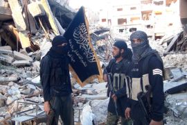 Fighters from the al-Qaida group in the Levant, Al-Nusra Front, stand among destroyed buildings near the front line with Syrian government solders in Yarmuk Palestinian refugee camp, south of Damascus on September 22, 2014. The Syrian Observatory for Human Rights says more than 180,000 people have been killed in the Syrian conflict since it erupted in March 2011, while the United Nations puts the figure at 191,000. AFP PHOTO/ RAMI AL-SAYED