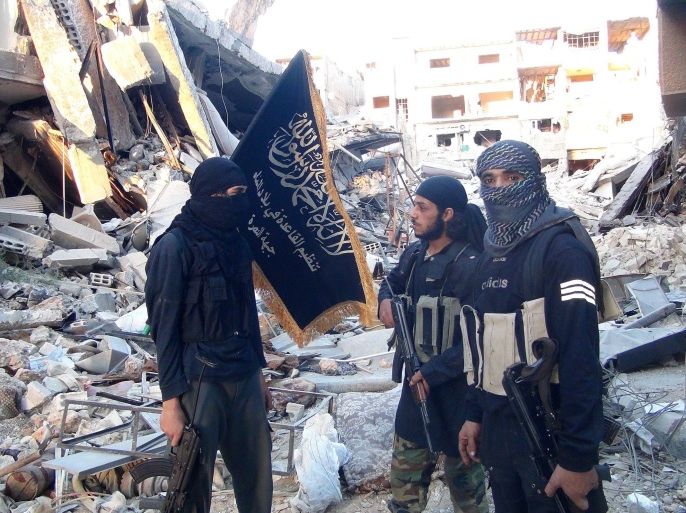 Fighters from the al-Qaida group in the Levant, Al-Nusra Front, stand among destroyed buildings near the front line with Syrian government solders in Yarmuk Palestinian refugee camp, south of Damascus on September 22, 2014. The Syrian Observatory for Human Rights says more than 180,000 people have been killed in the Syrian conflict since it erupted in March 2011, while the United Nations puts the figure at 191,000. AFP PHOTO/ RAMI AL-SAYED