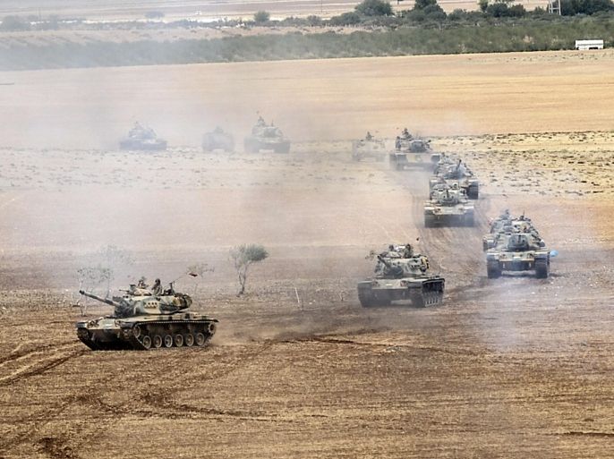 Turkish army tanks take position near the Syrian border on September 29, 2014 in Suruc after three mortars hit the Turkish side. Turkey's government may on September 29, 2014 send motions to parliament requesting extended mandates for military action in Iraq and Syria, so Ankara can join the coalition against the Islamic State. AFP PHOTO/BULENT KILIC