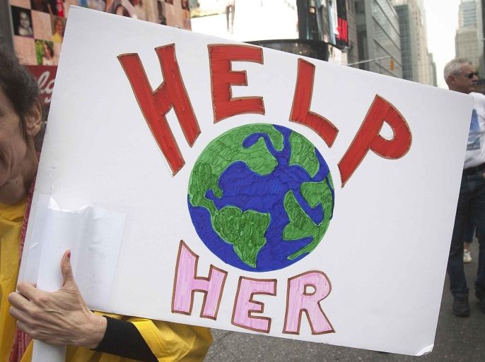 A protester carries a sign during the "People's Climate March" in the Manhattan borough of New York September 21, 2014. The international day of action on climate change brought hundreds of thousands of people onto the streets of New York City on Sunday, easily exceeding organizers' hopes for the largest protest on the issue in history. REUTERS/Carlo Allegri (UNITED STATES - Tags: SOCIETY ENVIRONMENT CIVIL UNREST POLITICS)