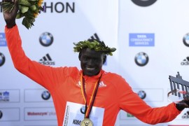 Dennis Kimetto of Kenya holds up his trophy as he celebrates during the awards ceremony for the 41st Berlin marathon, September 28, 2014. Kimetto finished in a time of two hours, two minutes and 57 seconds setting a new marathon world record. REUTERS/Hannibal Hanschke (GERMANY - Tags: SPORT ATHLETICS)