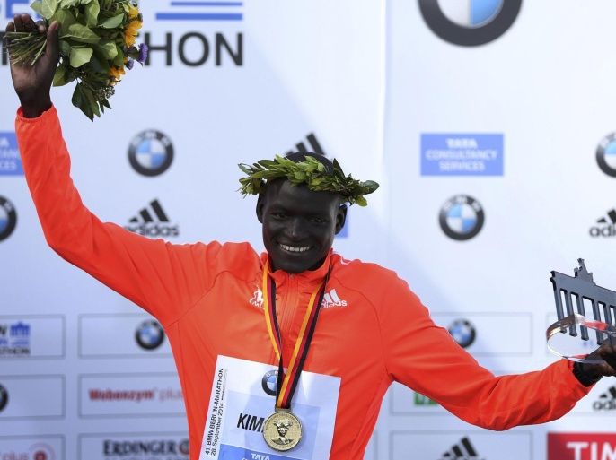 Dennis Kimetto of Kenya holds up his trophy as he celebrates during the awards ceremony for the 41st Berlin marathon, September 28, 2014. Kimetto finished in a time of two hours, two minutes and 57 seconds setting a new marathon world record. REUTERS/Hannibal Hanschke (GERMANY - Tags: SPORT ATHLETICS)