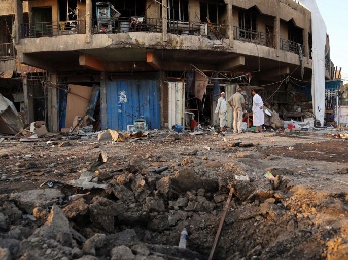 People inspect the aftermath of a car bomb attack in Baghdad, Iraq, Tuesday, Sept. 23, 2014. The bomb exploded in a commercial area of eastern Baghdad on Monday night, officials said. (AP Photo/Karim Kadim)