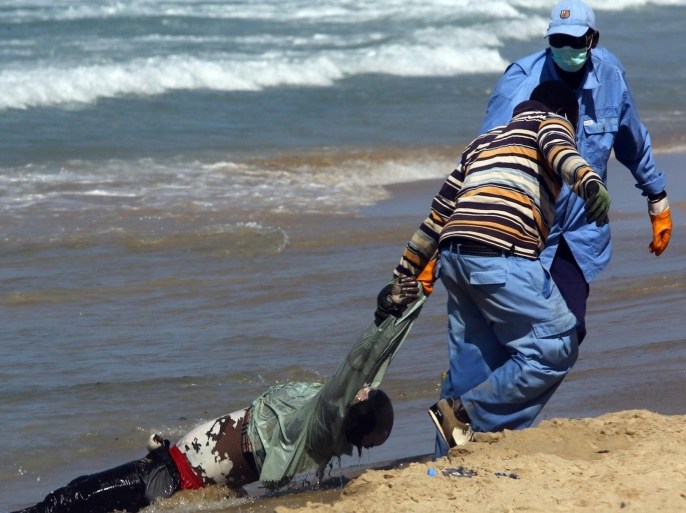GRAPHIC CONTENT Rescue workers pull the body of an illegal immigrant onto shore of al-Qarbole, some 60 kilometres east of Tripoli on August 25, 2014 after a boat carrying 200 illegal immigrants from sub-Sahara Africa sunk off the Libyan capital two days earlier. Libya, which is mired in unrest and political chaos, has been a launchpad for illegal migrants seeking a better life in Europe but who turn to people smugglers to get them across the Mediterranean. AFP PHOTO / MAHMUD TURKIA