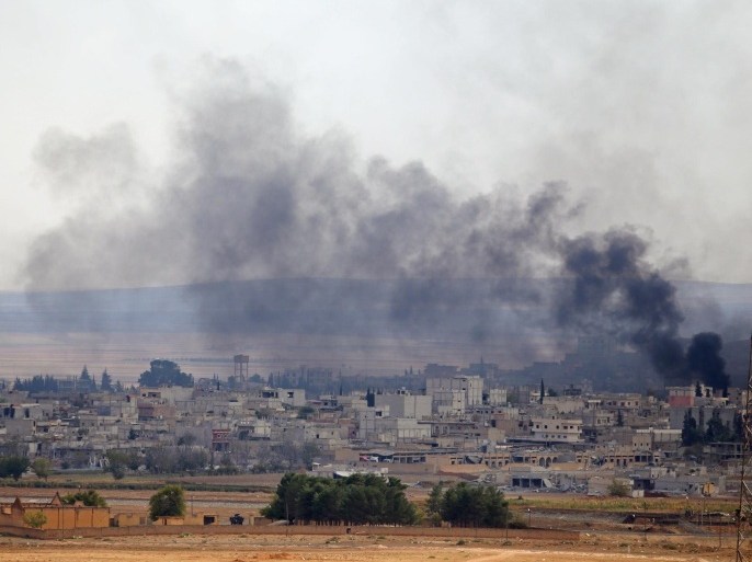 SANLIURFA, TURKEY - OCTOBER 26: Black smoke rising from Kobani (Ayn al-Arab) town of northern Syria during the intensified clashes between Islamic State of Iraq and Levant (ISIL) members and Kurdish armed groups, is viewed from Suruc district of Turkey's Sanliurfa near Turkish-Syrian border crossing on October 26, 2014.