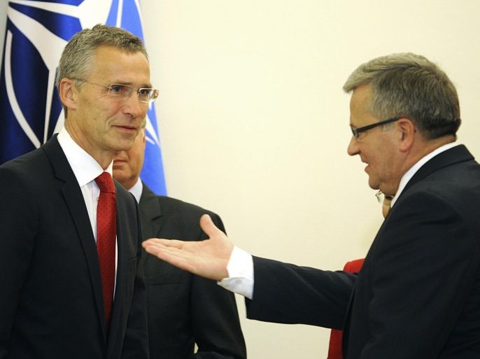Polish President Bronislaw Komorowski, right, gestures before talks with NATO Secretary General Jens Stoltenberg, left, in Warsaw, Poland, Monday, Oct. 6, 2014. Stoltenberg came to Poland for his first visit abroad after taking over the leadership of the alliance. (AP Photo/Alik Keplicz)