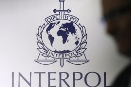 A man passes an Interpol logo during the handing over ceremony of the new premises for Interpol's Global Complex for Innovation, a research and development facility, in Singapore September 30, 2014. Interpol, the world's largest police organisation, is opening a centre in Singapore focused on fighting cyber crime, which many countries, it says, are poorly equipped to contain. Picture taken September 30, 2014. REUTERS/Edgar Su (SINGAPORE - Tags: CRIME LAW SCIENCE TECHNOLOGY)