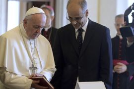Pope Francis receives a gift from Andorra's Head of Government Antoni Marti (R) during a private audience at the Vatican September 5, 2014. REUTERS/Filippo Monteforte/Pool (VATICAN - Tags: RELIGION)