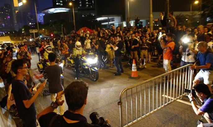 Protesters try to block an avenue with metal fences outside the offices of Hong Kong's Chief Executive Leung Chun-ying in Hong Kong October 2, 2014. Hong Kong authorities on Thursday urged thousands of pro-democracy protesters to immediately end their blockade of the city centre and said any attempt to occupy administrative buildings would be met with a resolute and firm response. REUTERS/Carlos Barria (CHINA - Tags: CIVIL UNREST POLITICS)