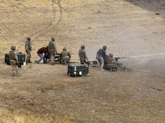 British soldiers instruct Kurdish Peshmerga fighters during training at a shooting range in Arbil, in Iraq's northern autonomous Kurdistan region, October 16, 2014. British army trainers have begun teaching Kurdish Peshmerga fighters how to fire and maintain heavy machineguns, as part of their fight against Islamic State (IS) militants. Picture taken October 16, 2014. REUTERS/Azad Lashkari (IRAQ - Tags: CRIME LAW POLITICS CIVIL UNREST CONFLICT)