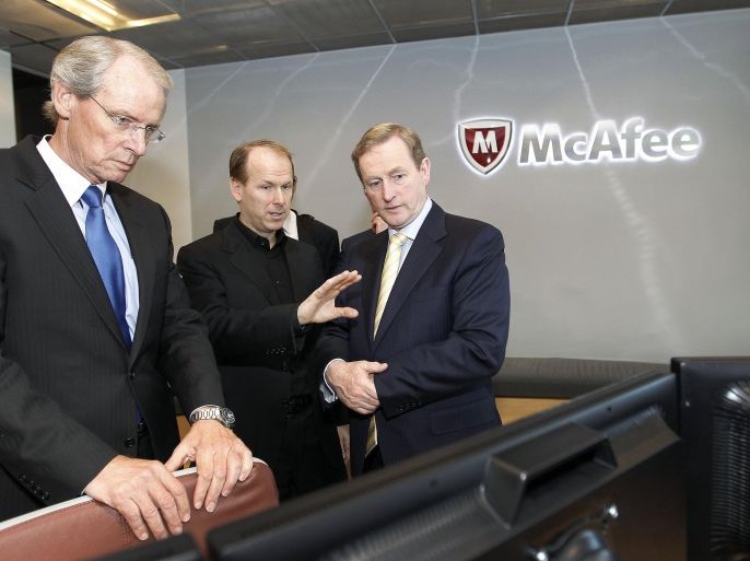 IMAGE DISTRIBUTED FOR IDA IRELAND - McAfee Inc. co-president's Todd Gebhart, left, Michael DeCesare, center, and Irish Prime Minister An Taoiseach Enda Kenny, check on the computer in the War Room at McAfee headquarters in Santa Clara, Calif., Thursday, March 21, 2013. Irish Prime Minister An Taoiseach Enda Kenny, today met with McAfee, the world’s largest dedicated security company, to announce the company’s establishment of a worldwide Centre of Excellence for Enterprise Security Solutions in Cork with the creation of up to 60 new high quality jobs (Tony Avelar/AP Images for IDA Ireland)