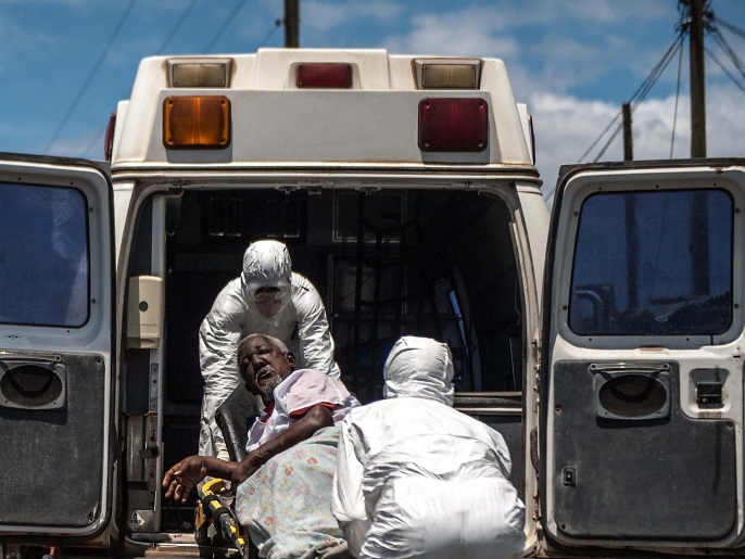 ‪عمال صحة في ليبيريا ينقلون مسنا يشتبه في إصابته بإيبولا‬ (غيتي)