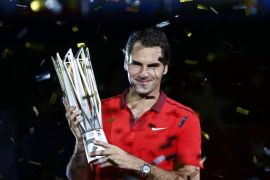 Roger Federer of Switzerland poses with the trophy after winning the men's singles final match against Gilles Simon of France at the Shanghai Masters tennis tournament in Shanghai October 12, 2014. Federer claimed one of the few titles to have previously eluded him after he overcame a sluggish start to beat injured Frenchman Simon in the final of the Shanghai Masters on Sunday. REUTERS/Aly Song (CHINA - Tags: SPORT TENNIS)