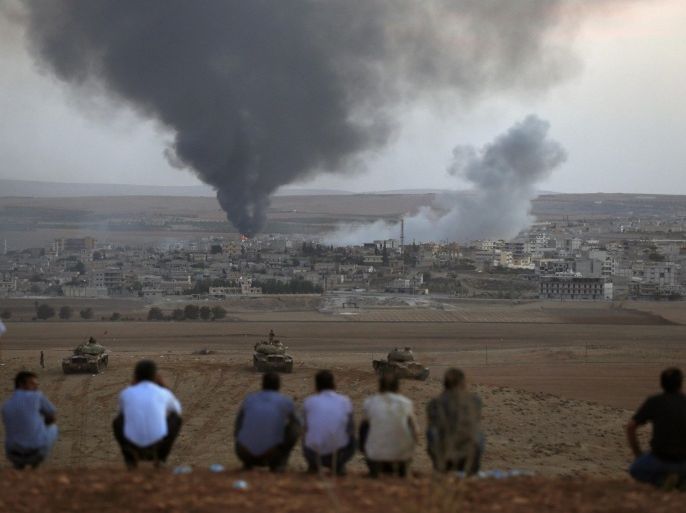 Smoke rises in the Syrian town of Kobani as Turkish Kurds watch near the Mursitpinar border crossing on the Turkish-Syrian border in the southeastern town of Suruc October 9, 2014. Islamic State fighters seized more than a third of the Syrian border town of Kobani, a monitoring group said on Thursday, as U.S.-led air strikes failed to halt their advance and Turkish forces nearby looked on without intervening. REUTERS/Umit Bektas (TURKEY - Tags: POLITICS SOCIETY IMMIGRATION CIVIL UNREST CONFLICT TPX IMAGES OF THE DAY)